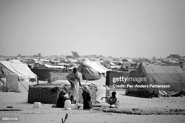 Refugees make mud bricks to construct a home at the Oure Cassoni refugee camp on July 26, 2007 about 23 kilometers outside Bahai, Chad. Since 2003,...
