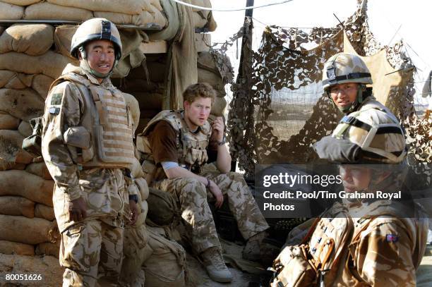 Prince Harry sits with a group of Gurkha soldiers after firing a machine gun from the observation post on JTAC Hill, close to FOB Delhi , on January...