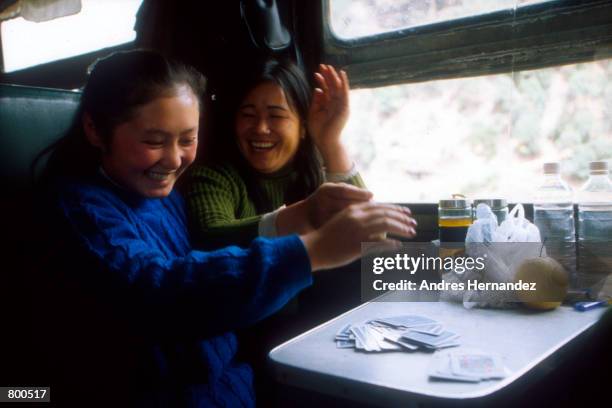 File Photo: Passengers pass the time on the train to Guilan with a game of cards, January China. People often wait for days to purchase tickets for...