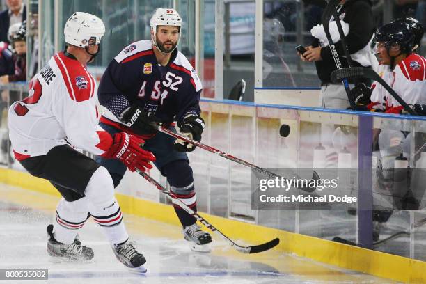 Brandon Bollig of the USA makes a pass against Mike Commodore of Canada during the Ice Hockey Classic match between the United States of America and...