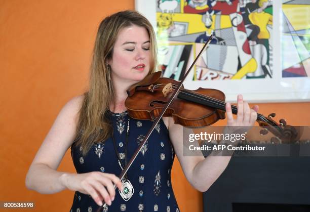 Violinist Lara St. John poses with her instrument, an anonymously donated Salabue Guadagnini from 1779, during an interview with AFP at her apartment...