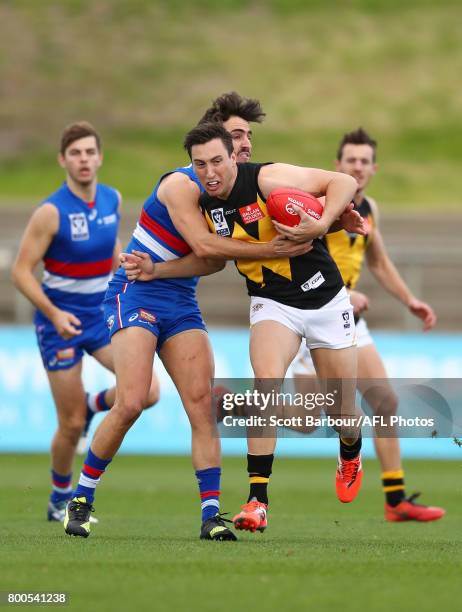 Sam Wright of Werribee is tackled during the 2017 VFL round 10 match between the Footscray Bulldogs and the Werribee Tigers at Whitten Oval on June...