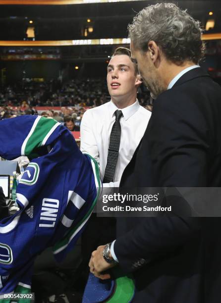 Kole Lind, 33rd overall pick of the Vancouver Canucks, puts on his jersey during the 2017 NHL Draft at United Center on June 24, 2017 in Chicago,...