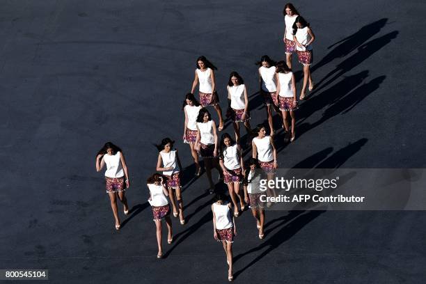 Grid girls walk at the Baku City Circuit during the qualifying session for the Formula One Azerbaijan Grand Prix in Baku on June 24, 2017. / AFP...