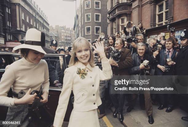 English actress Tessa Wyatt waves to reporters, photographers and members of the press as she arrives for her wedding to disc jockey and broadcaster...
