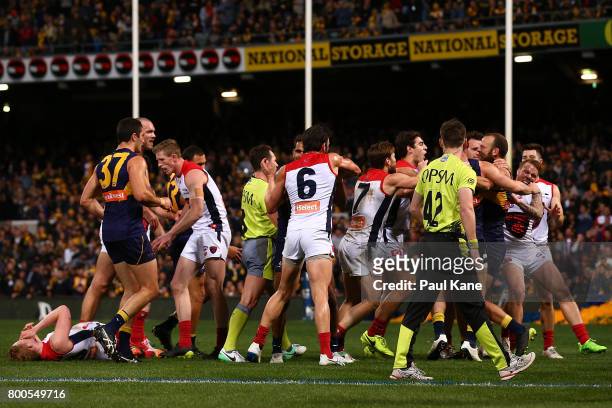 Players from both sides become involved in a melee after incident between Will Schofield of the Eagles and Clayton Oliver of the Demons during the...