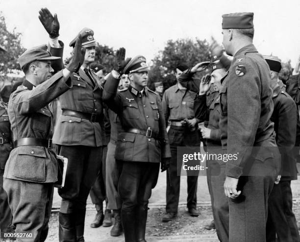 Picture released on May 9, 1945 of German defeated Nazis rending their last party salutes at the headquarters 66th infantry division before...
