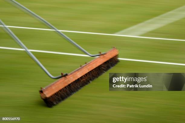 Grounds men brush the court on day six at Queens Club on June 24, 2017 in London, England.