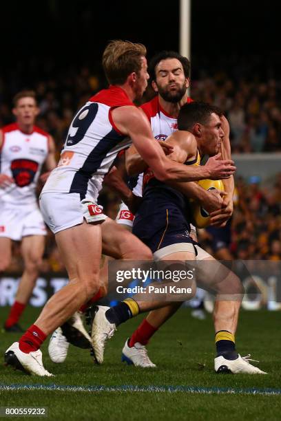 Luke Shuey of the Eagles gets tackled by Mitch Hannan and Jordan Lewis of the Demons during the round 14 AFL match between the West Coast Eagles and...