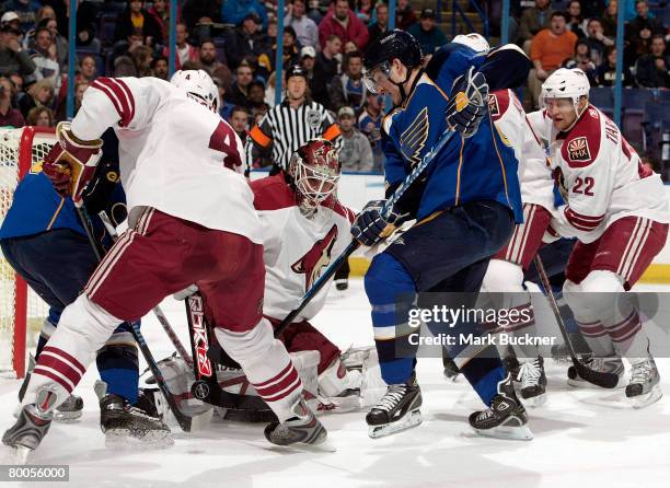 Ilya Bryzgalov of the Phoenix Coyotes keeps his eyes on the puck as his teammates scramble with the St. Louis Blues in front of the net February 28,...