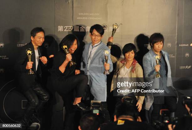 Taiwanese pop band Mayday hold their trophies after winning the Best Mandarin Album during the 28th Golden Melody Awards in Taipei on June 24, 2017....