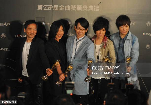 Taiwanese pop band Mayday hold their trophies after winning the Best Mandarin Album during the 28th Golden Melody Awards in Taipei on June 24, 2017....