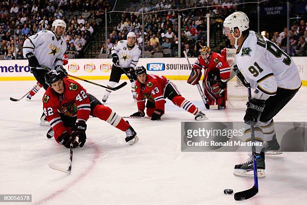 Center Brad Richards of the Dallas Stars looks for an open player while Jordan Hendry and James Wisniewski of the Chicago Blackhawks play defense at...