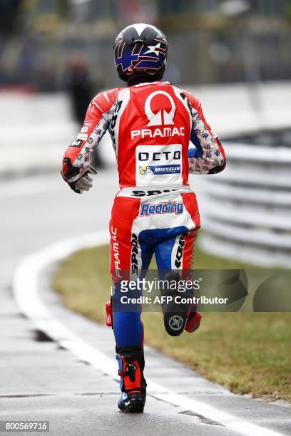 British MotoGP rider Scott Redding of the Octo Pramac Racing team runs along the track after he crashed during qualifications for the Motorcycling...