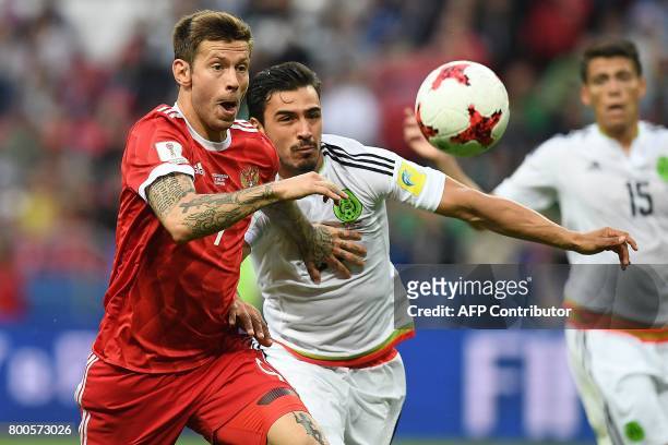 Russia's forward Fedor Smolov vies for the ball against Mexico's defender Diego Reyes during the 2017 Confederations Cup group A football match...