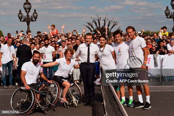 French President Emmanuel Macron poses with former French tennis player Fabrice Santoro , French wheelchair tennis player Michael Jeremiasz and...