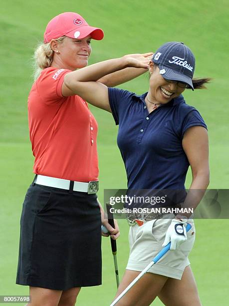 Norwegian Suzann Pettersen gives a hi-five to South Korean Jimin Kang after she made a birdie on the 17th hole during the round two HSBC Women's...