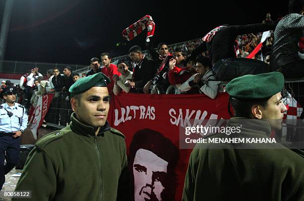 Israeli border policemen secure the field in front of Israeli Arab Bnei Sakhnin fans during their national football cup match against Beitar...