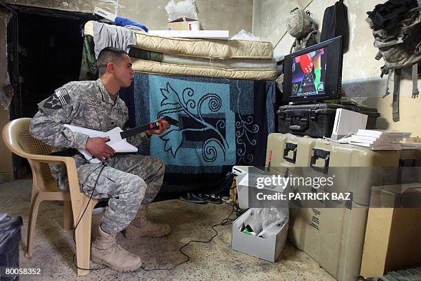 Soldier from the 2nd Battallion 12th Field Artillery Regiment, 4-2 SBCT, plays Guitar Hero on Nintedo Wii as he takes time off at a combat outpost in...