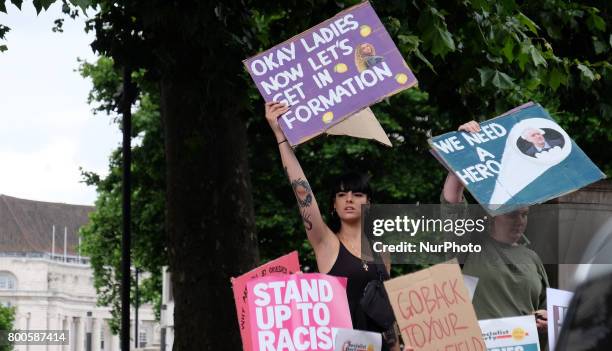 Protestors hold banners as they rally outside Downing street, in London, on June 24, 2017. Hundreds of people gather outside Downing street to...