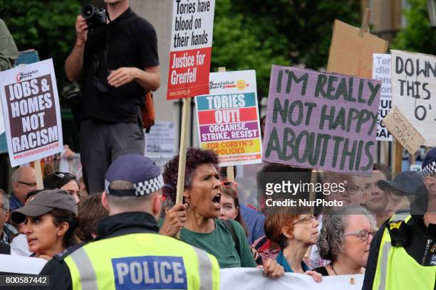 Protestors hold banners as they rally outside Downing street , in London, on June 24, 2017. Hundreds of people gather outside Downing street to...