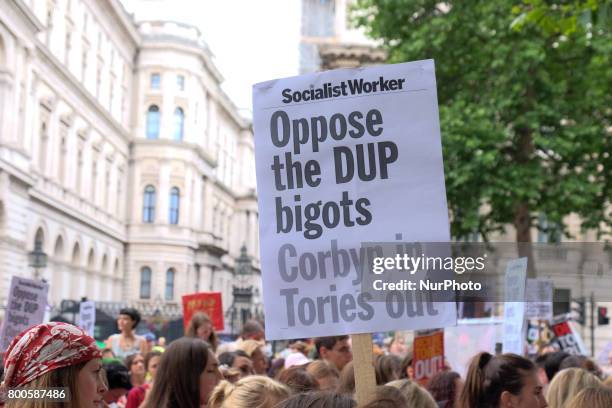 People hold placards criticising the DUP, in London, on June 24, 2017. Hundreds of people gather outside Downing street to protest against the...