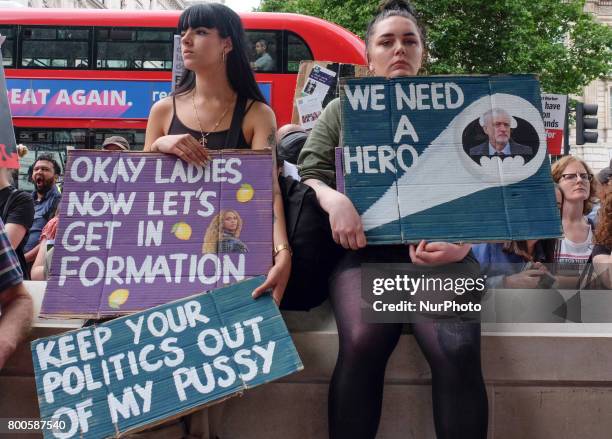 Protestors hold banners as they rally outside Downing street, in London, on June 24, 2017. Hundreds of people gather outside Downing street to...