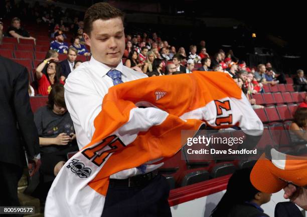 Matthew Strome puts on his jersey after being selected 106th overall by the Philadelphia Flyers during the 2017 NHL Draft at United Center on June...