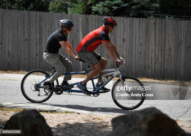 Brian Curran with Eyecycle, right, guides blind participant Peter Chan on a tandem bicycle at the Colorado Center For the Blind June 24, 2017 in...