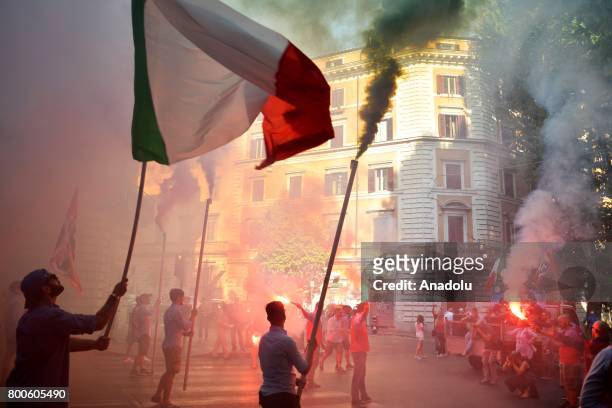 People carry flags and flares during a protest against the law on Jus Soli, which would give birthright citizenships to children born to refugees...