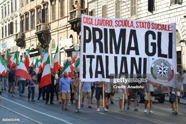 People carry a banner that translates "Home, Work, School, State : Primarily Italian's" in Rome against the law on ius soli which would give...