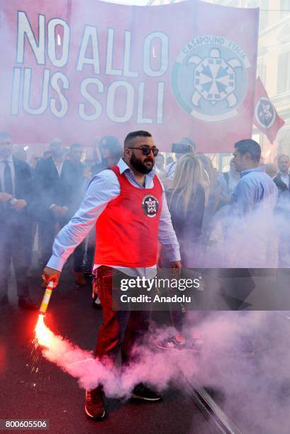 Protester carries a flare during a protest against the law on Jus Soli, which would give birthright citizenships to children born to refugees living...