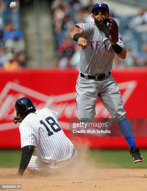 Second baseman Rougned Odor of the Texas Rangers gets the force out on Didi Gregorius of the New York Yankees and throws to first to complete a...