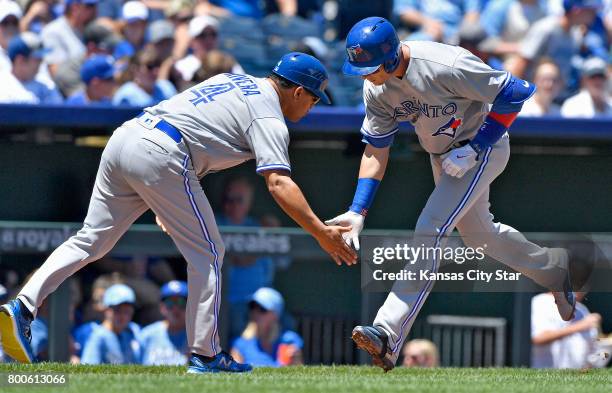 The Toronto Blue Jays' Troy Tulowitzki, right, is congratulated by third base coach Luis Rivera on a solo home run in the second inning against the...