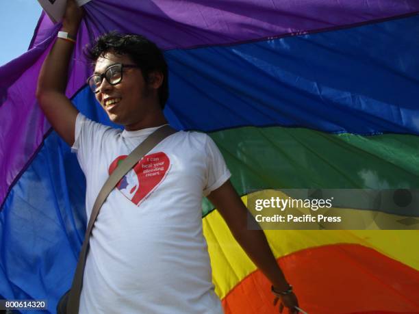 Participant holds a rainbow flag over his head as shade during the annual LGBT Pride Parade in Marikina City, east of Manila, Philippines on...