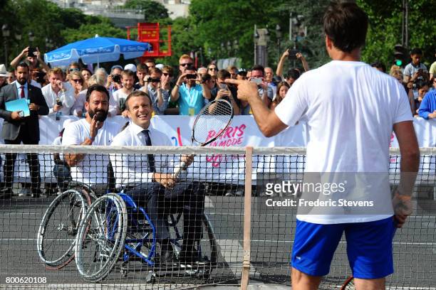 French President Emmanuel Macron plays tennis sitting in a wheelchair with Michael Jeremiasz and Fabrice Santoro on Alexandre III bridge as Paris...