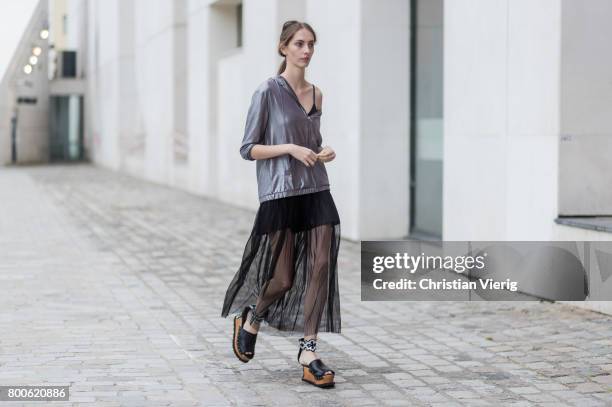 Model wearing a sheer skirt, silver jacket outside Sacai during Paris Fashion Week Menswear Spring/Summer 2018 Day Four on June 24, 2017 in Paris,...