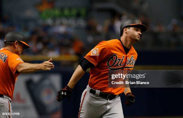 Trey Mancini of the Baltimore Orioles celebrates with third base coach Bobby Dickerson hitting a two-run home run off of pitcher Jumbo Diaz of the...