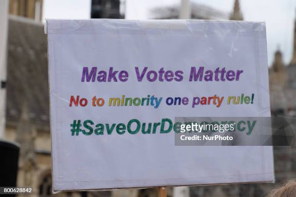 Placard is held up in front of Parliament. The Make votes matter group, calling for a change in the voting system to give smaller parties more seats...