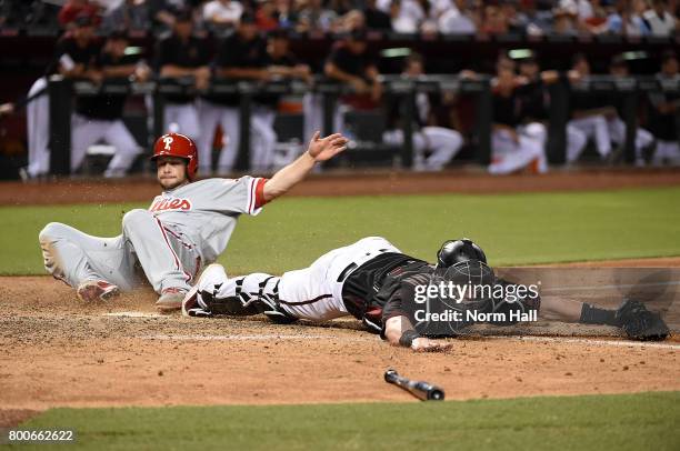 Chris Herrmann of the Arizona Diamondbacks stretches to catch a throw while keeping his toe on home plate to get a force out as Daniel Nava of the...