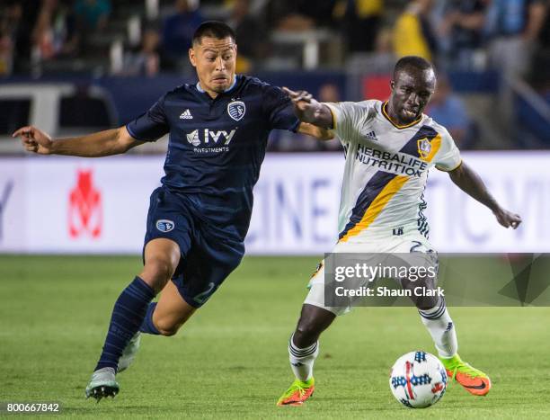 Ema Boateng of Los Angeles Galaxy with the ball as Roger Espinoza of Sporting Kansas City defends during the Los Angeles Galaxy's MLS match against...