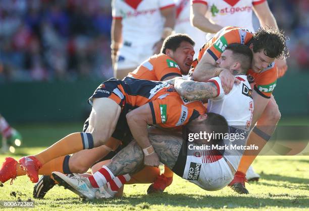 Josh Dugan of the Dragons is tackled during the round 16 NRL match between the St George Illawarra Dragons and the Newcastle Knights at UOW Jubilee...