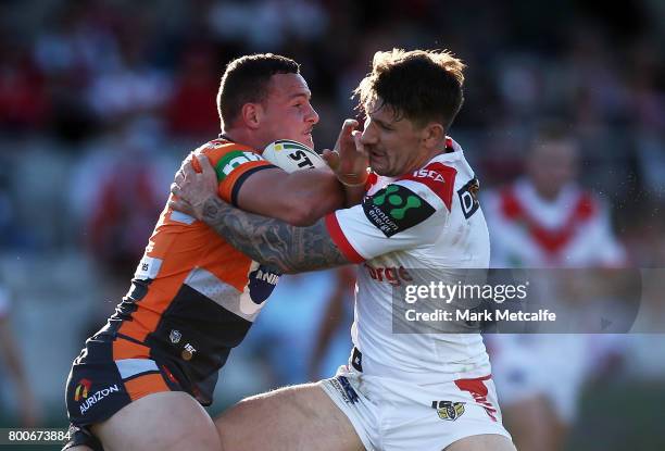 Jaelen Feeney of the Knights is tackled by Gareth Widdop of the Dragons during the round 16 NRL match between the St George Illawarra Dragons and the...