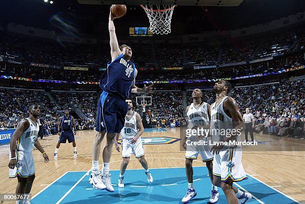 Dirk Nowitzki of the Dallas Mavericks slam dunks over David West and Tyson Chandler of the New Orleans Hornets during the game on February 20, 2008...