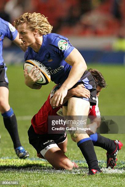 Jaco van Schalkwyk tackles Nick Cummins during the Super 14 Round 3 match between Lions and Western Force held at Ellis Park Stadium on February 29,...