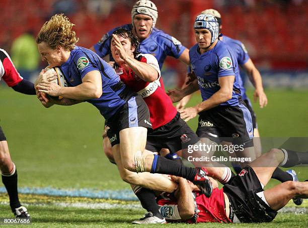 Jaco van Schalkwyk and Cobus Grobbelaar tackle Nick Cummins during the Super 14 Round 3 match between Lions and Western Force held at Ellis Park...