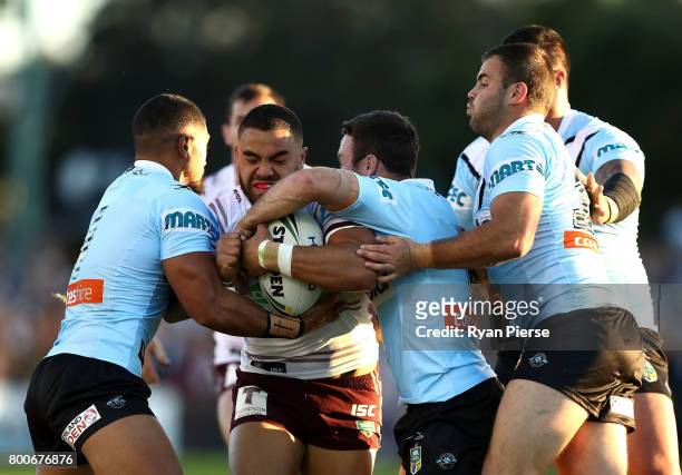 Dylan Walker of the Sea Eagles is tackled by James Maloney and Wade Graham of the Sharks during the round 16 NRL match between the Cronulla Sharks...