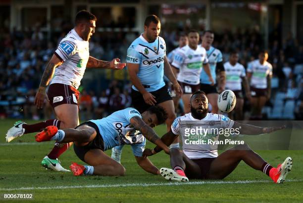 Akuila Uate of the Sea Eagles is tackled by Sosaia Feki of the Sharks during the round 16 NRL match between the Cronulla Sharks and the Manly Sea...