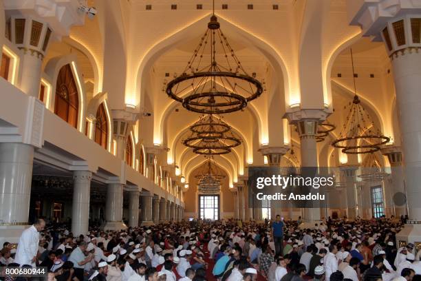 Muslims gather to perform Eid al-Fitr prayer at Abdul Wahhab Mosque in Doha, Qatar on June 25, 2017. Eid al-Fitr is a religious holiday celebrated by...
