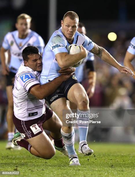 Luke Lewis of the Sharks is tackled during the round 16 NRL match between the Cronulla Sharks and the Manly Sea Eagles at Southern Cross Group...